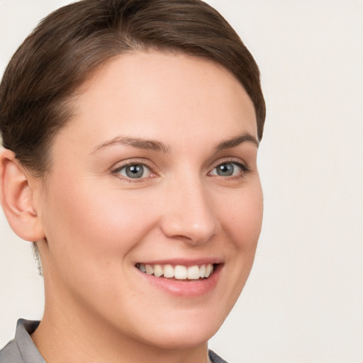 Joyful white young-adult female with short  brown hair and grey eyes