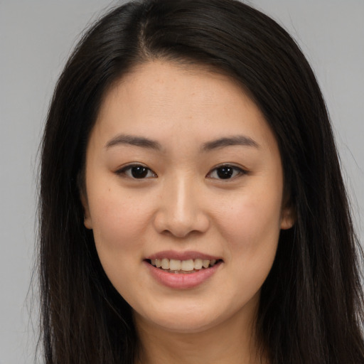 Joyful asian young-adult female with long  brown hair and brown eyes
