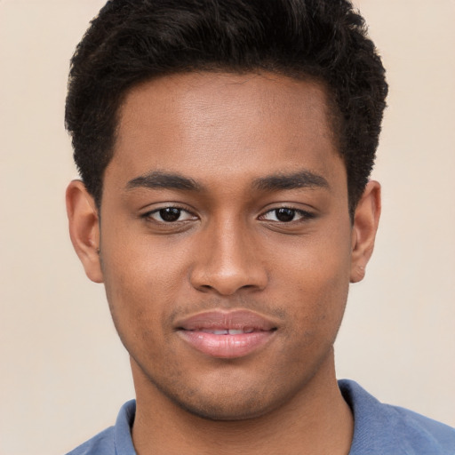 Joyful black young-adult male with short  brown hair and brown eyes