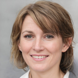 Joyful white adult female with medium  brown hair and grey eyes