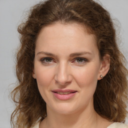 Joyful white young-adult female with medium  brown hair and green eyes