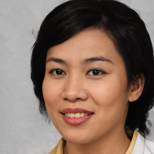Joyful asian young-adult female with medium  black hair and brown eyes