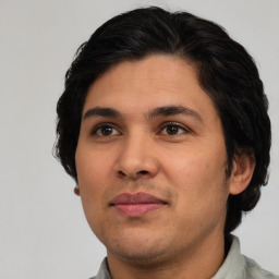 Joyful latino young-adult male with short  brown hair and brown eyes