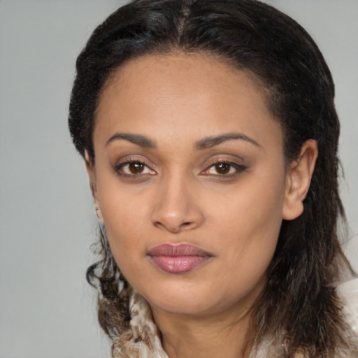 Joyful black young-adult female with long  brown hair and brown eyes