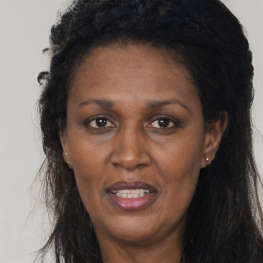 Joyful black adult female with long  black hair and brown eyes