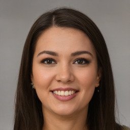 Joyful white young-adult female with long  brown hair and brown eyes