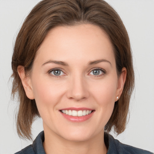 Joyful white young-adult female with medium  brown hair and grey eyes