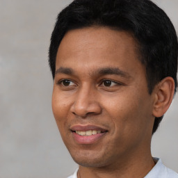 Joyful latino young-adult male with short  black hair and brown eyes