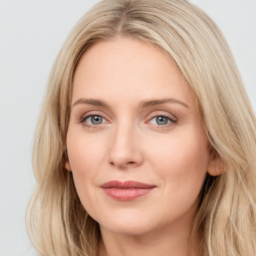 Joyful white young-adult female with long  brown hair and blue eyes