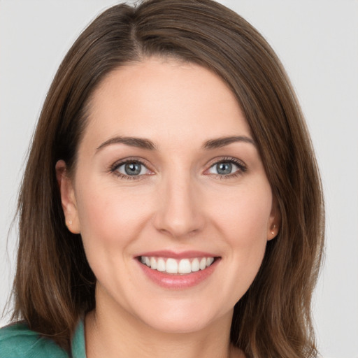 Joyful white young-adult female with long  brown hair and grey eyes