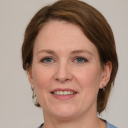 Joyful white adult female with medium  brown hair and grey eyes