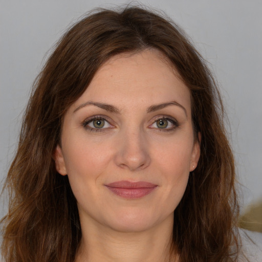 Joyful white young-adult female with long  brown hair and green eyes