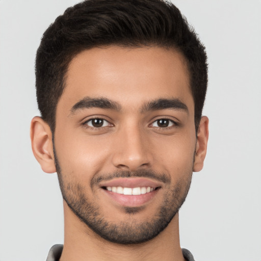 Joyful latino young-adult male with short  brown hair and brown eyes