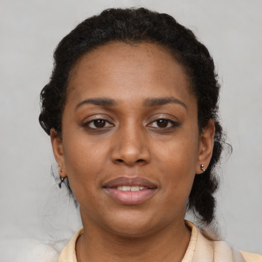 Joyful black adult female with short  black hair and brown eyes