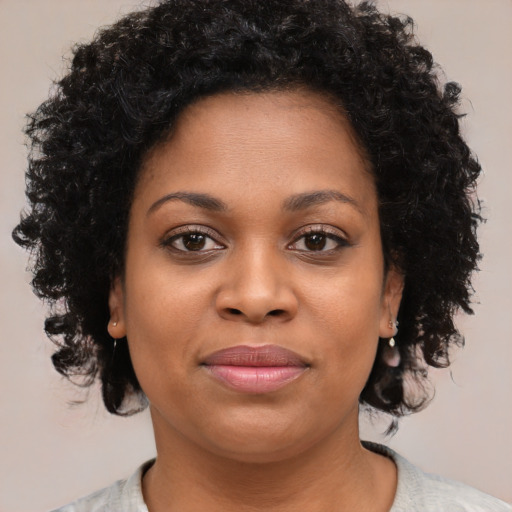 Joyful black young-adult female with medium  brown hair and brown eyes