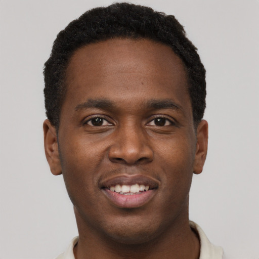 Joyful black young-adult male with short  brown hair and brown eyes