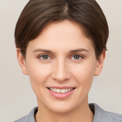 Joyful white young-adult female with short  brown hair and grey eyes