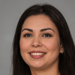 Joyful white young-adult female with long  brown hair and brown eyes