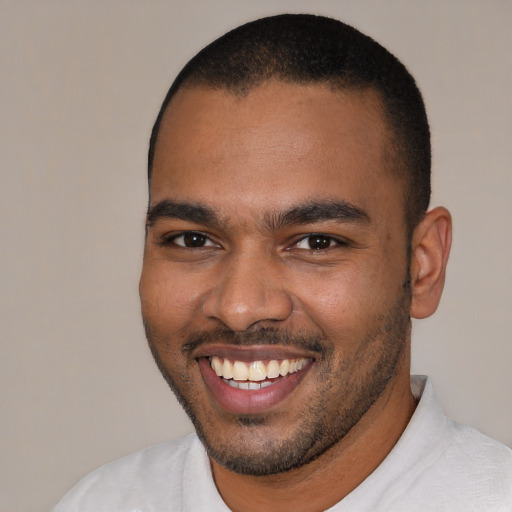 Joyful black young-adult male with short  black hair and brown eyes