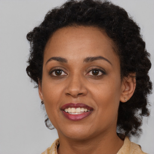 Joyful black adult female with medium  brown hair and brown eyes