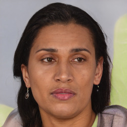 Joyful latino adult female with medium  brown hair and brown eyes