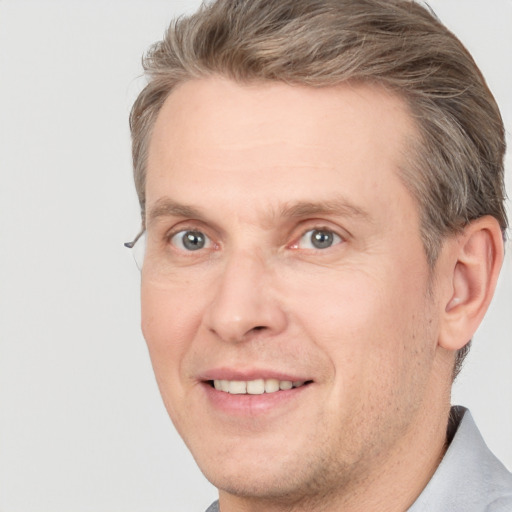 Joyful white adult male with short  brown hair and grey eyes