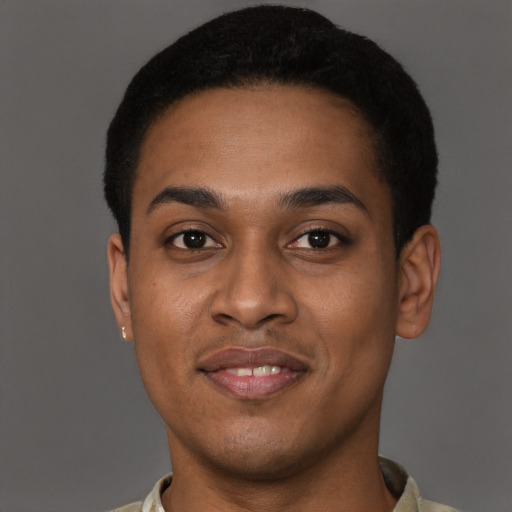 Joyful black young-adult male with short  brown hair and brown eyes
