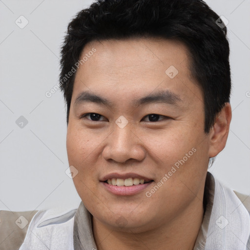 Joyful asian young-adult male with short  black hair and brown eyes