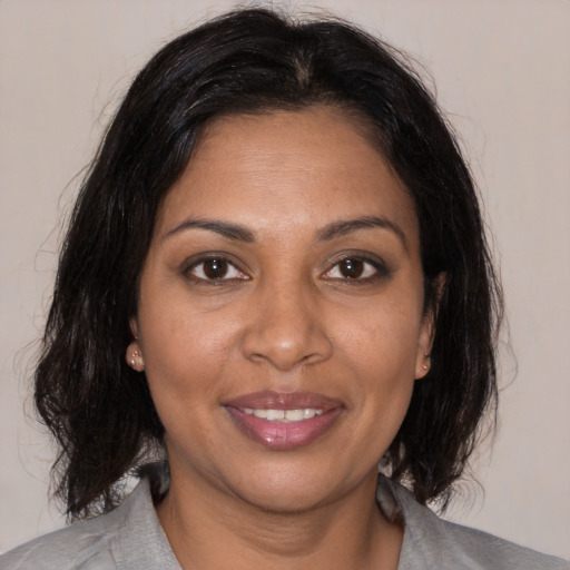 Joyful black adult female with medium  brown hair and brown eyes