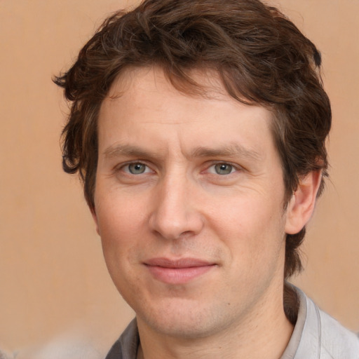 Joyful white adult male with medium  brown hair and brown eyes