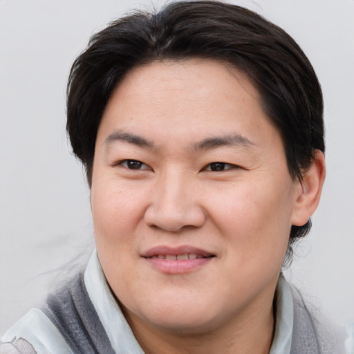 Joyful asian young-adult female with short  brown hair and brown eyes