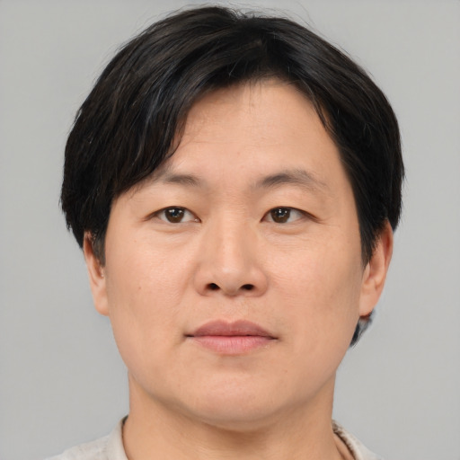 Joyful asian young-adult male with short  brown hair and brown eyes
