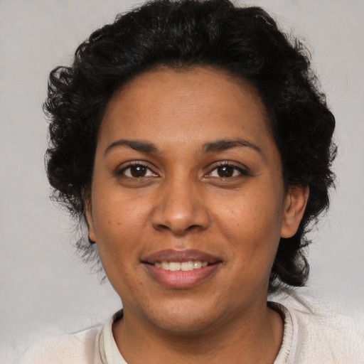 Joyful latino adult female with short  brown hair and brown eyes