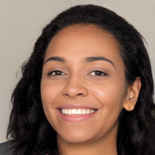 Joyful latino young-adult female with long  black hair and brown eyes