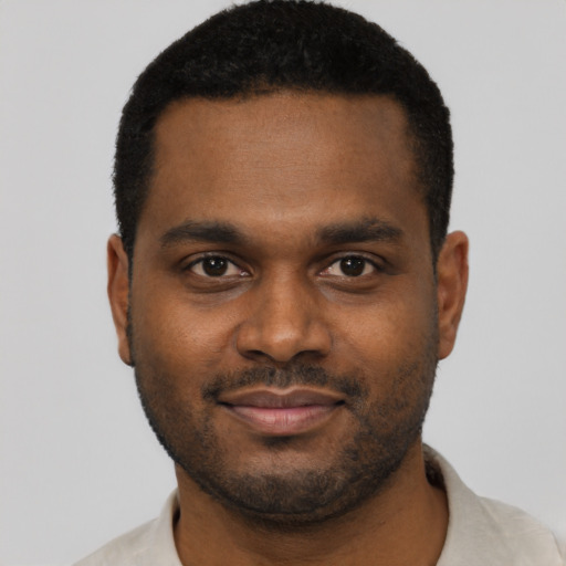 Joyful black young-adult male with short  black hair and brown eyes