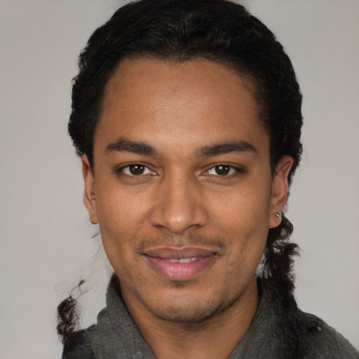 Joyful black young-adult male with short  black hair and brown eyes