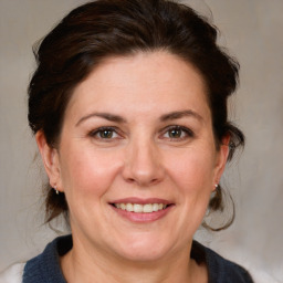 Joyful white adult female with medium  brown hair and grey eyes