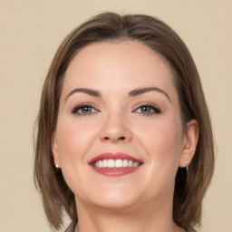 Joyful white young-adult female with medium  brown hair and grey eyes