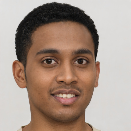 Joyful black young-adult male with short  brown hair and brown eyes