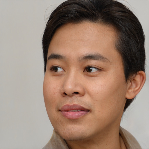 Joyful asian young-adult male with short  brown hair and brown eyes