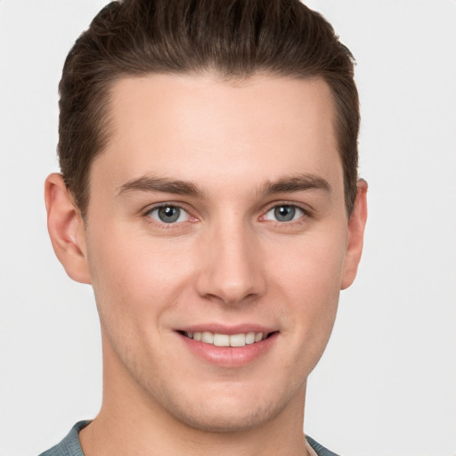 Joyful white young-adult male with short  brown hair and grey eyes