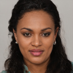 Joyful black young-adult female with long  brown hair and brown eyes