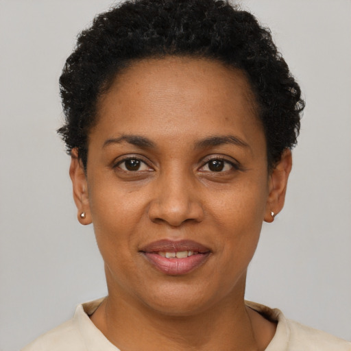 Joyful black young-adult female with short  black hair and brown eyes