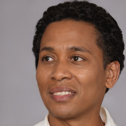 Joyful black adult male with short  black hair and brown eyes