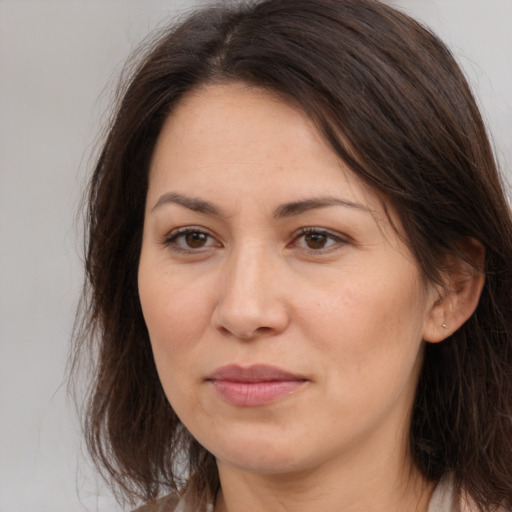 Joyful white adult female with long  brown hair and brown eyes