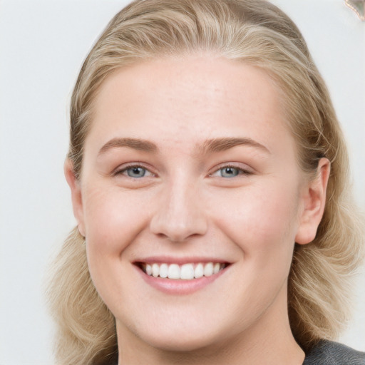 Joyful white young-adult female with long  brown hair and blue eyes