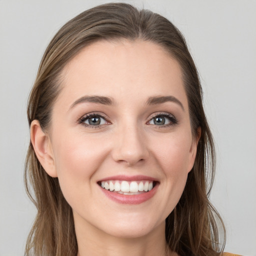 Joyful white young-adult female with long  brown hair and blue eyes