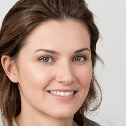 Joyful white young-adult female with medium  brown hair and grey eyes