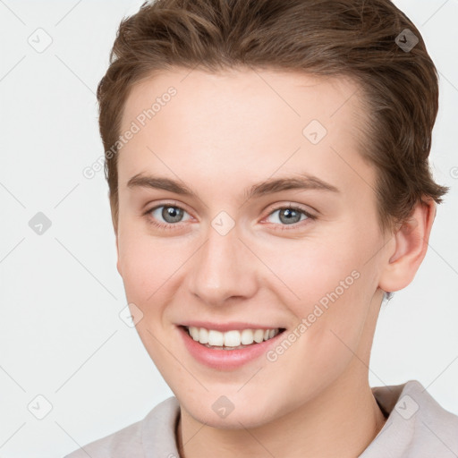 Joyful white young-adult female with short  brown hair and grey eyes