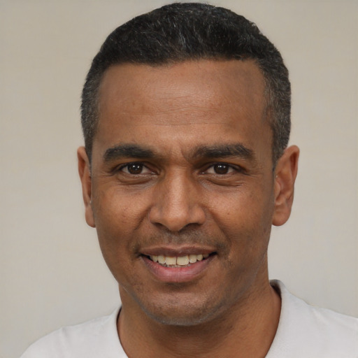 Joyful latino adult male with short  black hair and brown eyes